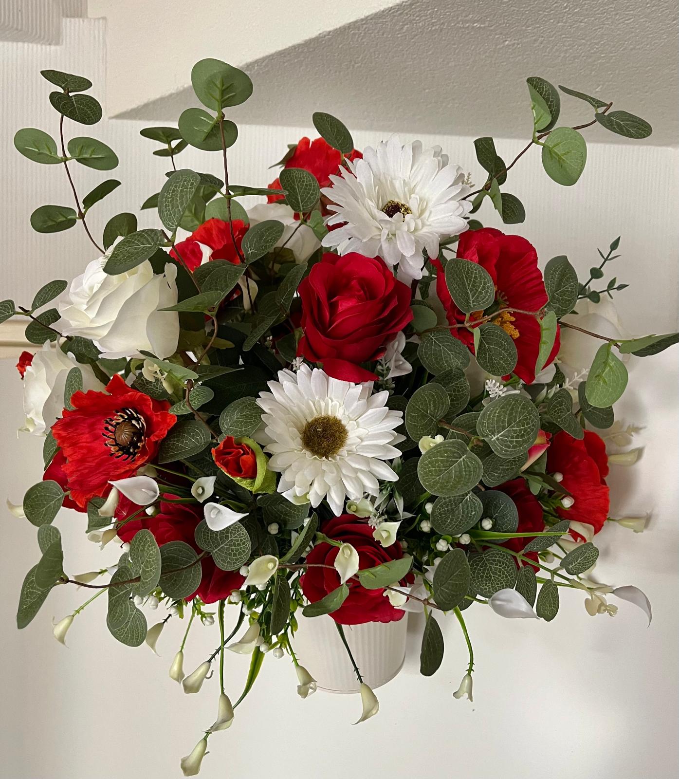 The hanging bucket with the red flowers