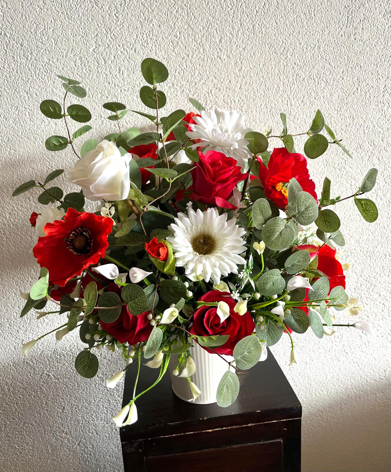 The hanging bucket with the red flowers