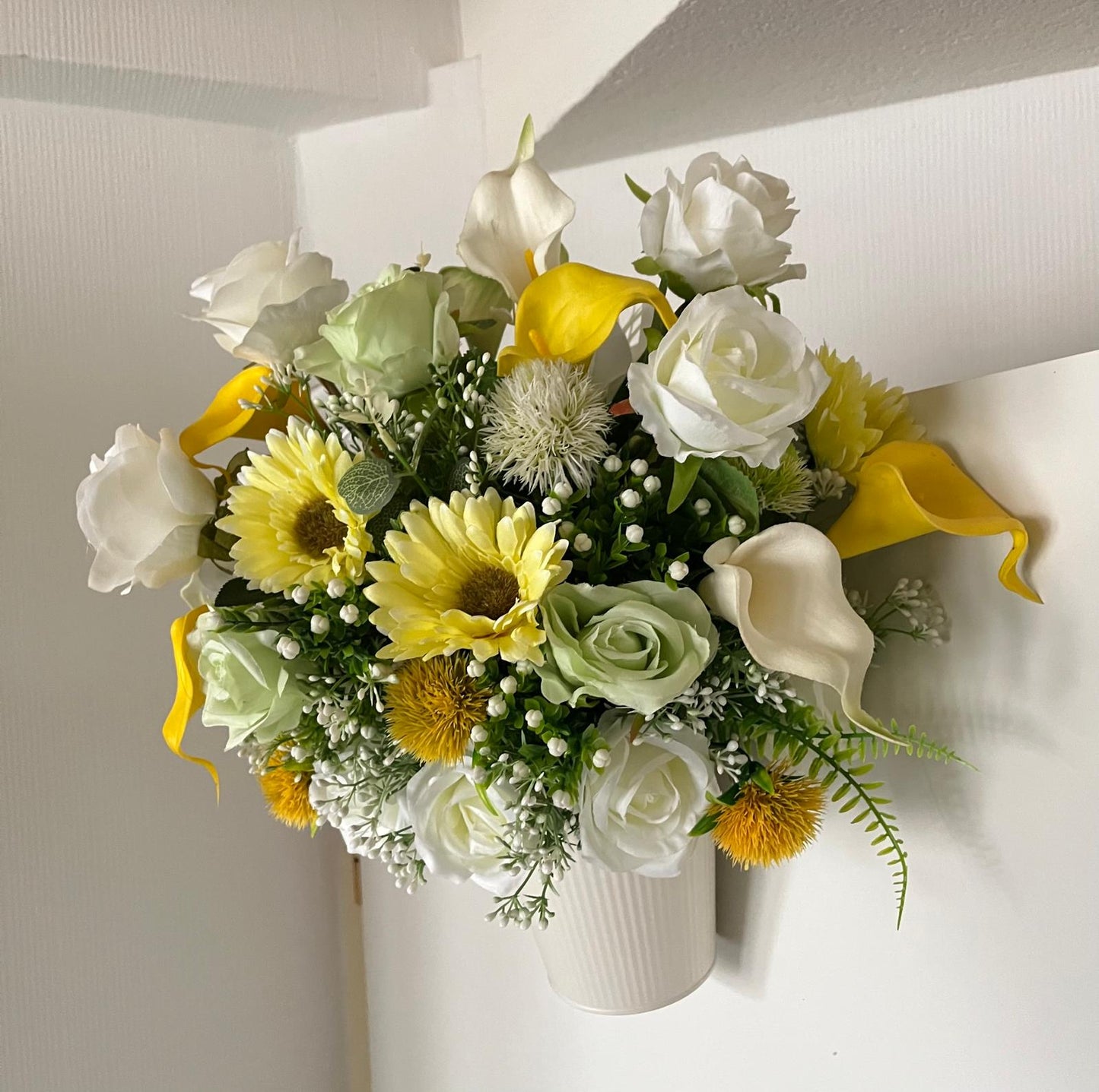 The hanging bucket with the yellow flowers